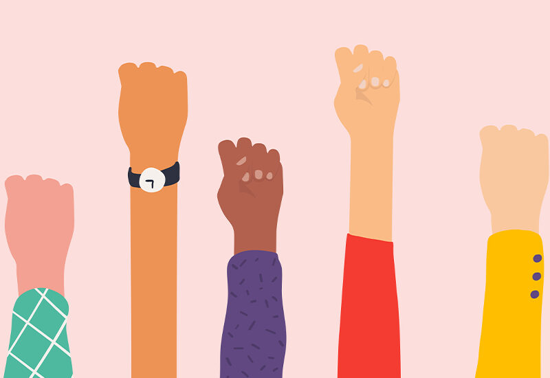 imagen de puños hacia arriba de distintas mujeres, reflejando diversidad de cuerpos y estilos.